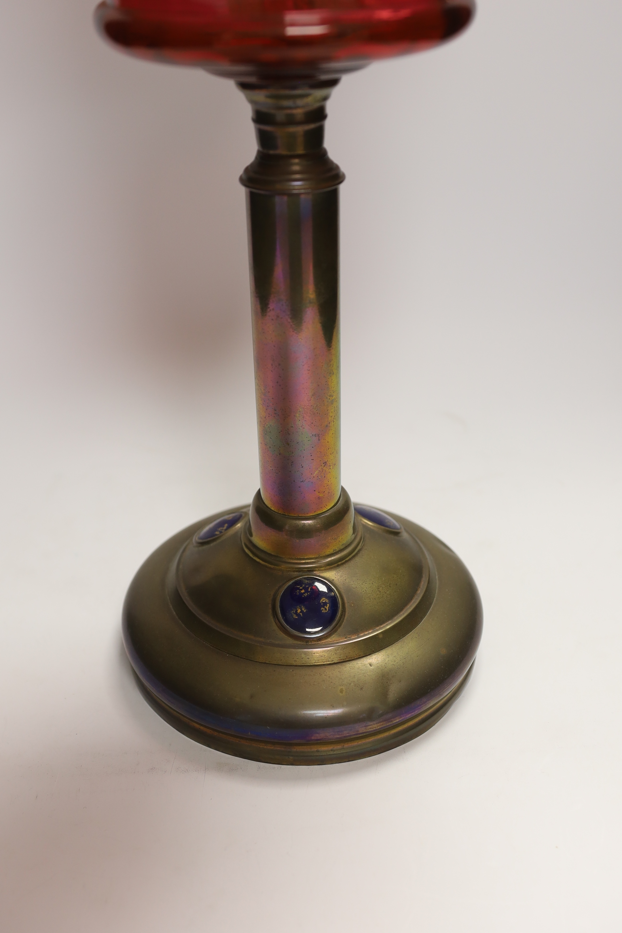 19th century brass oil lamp with cranberry glass reservoir, etched shade and Ruskin type cabochon panels to the base, 68cm high overall